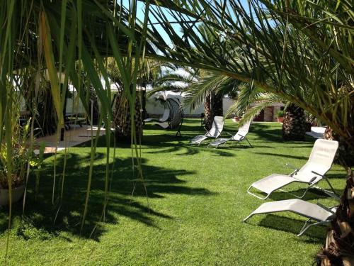 een rij ligstoelen in het gras bij The Bamboo villa in Casale la Cogna