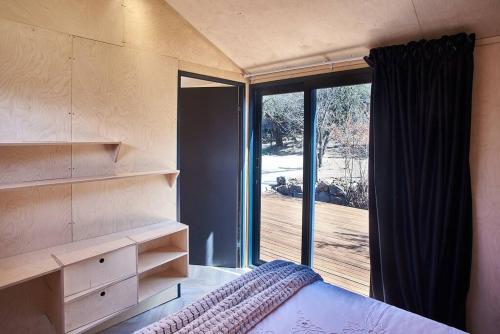 a bedroom with a bed and a large window at Clarens 'Gazza' Pod in Clarens