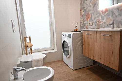 a bathroom with a washing machine and a sink at Garofoli Apartments in San Giovanni Lupatoto