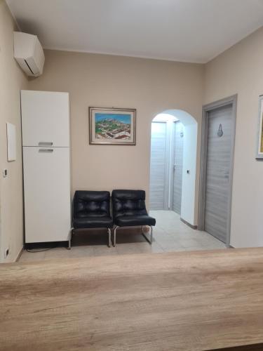 a waiting room with two black leather chairs in a room at Agriturismo Cara Terra Lucana in Chiaromonte