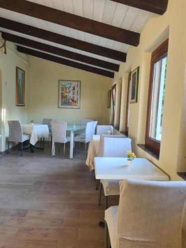 a dining room with white tables and chairs at Agriturismo Cara Terra Lucana in Chiaromonte