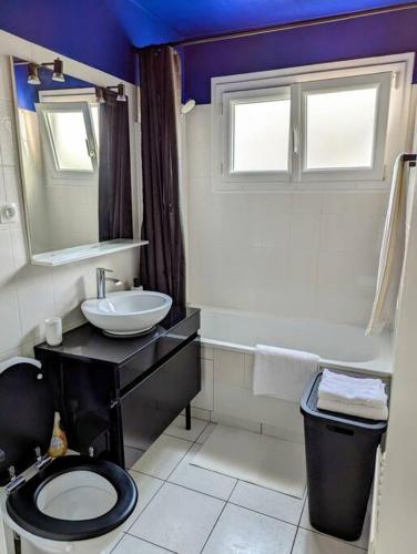 La salle de bains est pourvue de toilettes noires et d'un lavabo. dans l'établissement Séjour en famille ou amis à Disneyland & Paris, à Lognes