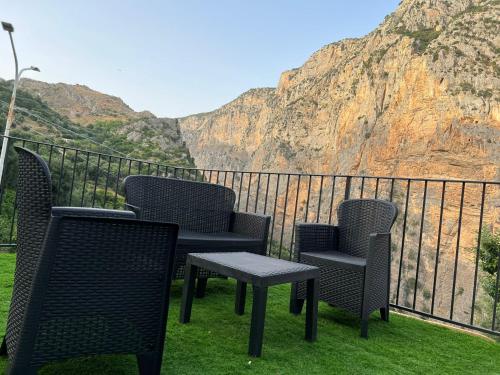 3 sillas y una mesa en un balcón con una montaña en L'oasi del raganello en Civita