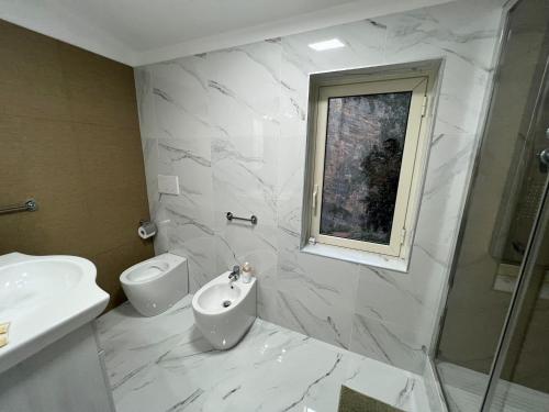a white bathroom with a sink and a toilet at L'oasi del raganello in Civita