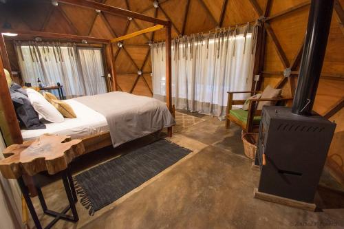 a bedroom with a bed and a wood stove at Momora distrito selva in Santa Ana