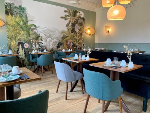 un restaurant avec des tables en bois et des chaises bleues dans l'établissement Hôtel des quatre saisons, à Guérande