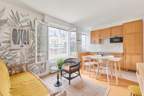 une cuisine et un salon avec une table et des chaises dans l'établissement Rent a Room apartments - Degas, à Paris