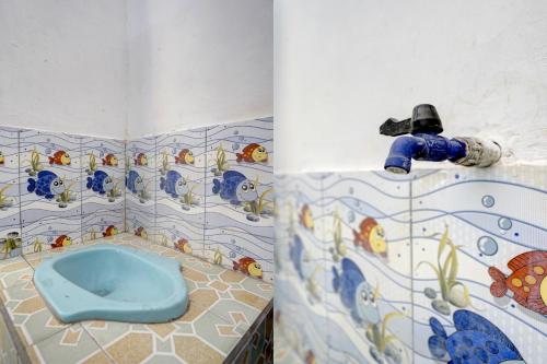 a bathroom with a blue toilet and a sink at SPOT ON 92906 Surya Indah Homestay Syariah in Mojokerto