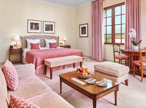 ヴァンスにあるシャトー サン マルタン ＆ スパ アン オトカー コレクション ホテルのベッドとテーブルが備わるホテルルームです。
