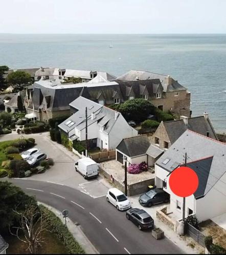 une rue avec des voitures garées devant une maison dans l'établissement Studio avec vue mer - Billiers, à Billiers