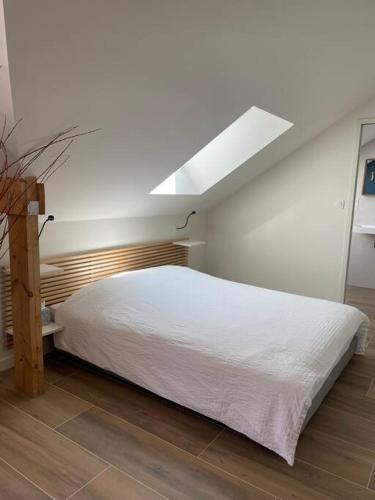 une chambre avec un lit blanc et une lucarne dans l'établissement Studio avec vue mer - Billiers, à Billiers
