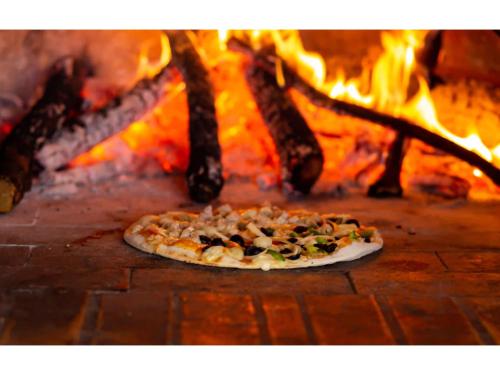 a pizza in front of a fire oven at Grand Palace Hotel Lusaka in Lusaka