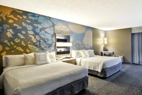 ヒューストンにあるCourtyard Houston I-10 West/Energy Corridorのベッド2台が備わる客室で、壁には絵画が飾られています。