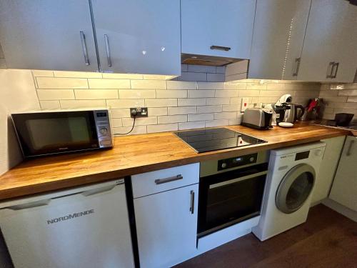 a kitchen with a microwave and a stove top oven at Guest Apartment in Dublin