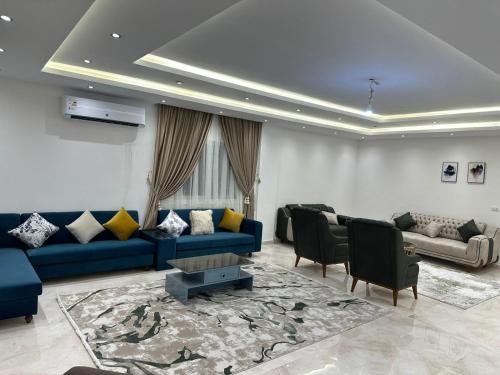 a living room with a blue couch and chairs at Two million hotel 2 in 6th Of October
