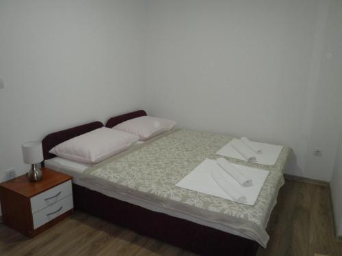 a small bedroom with a bed and a night stand at Apartments Sava in Zagreb