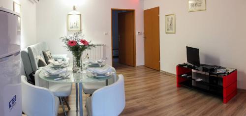 a dining room with a glass table and chairs at Apartments Sava in Zagreb