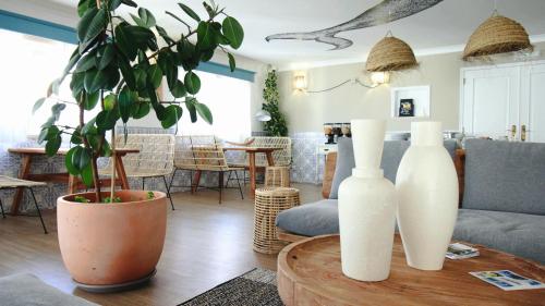 a living room with three white vases on a table at WOT Ericeira in Ericeira