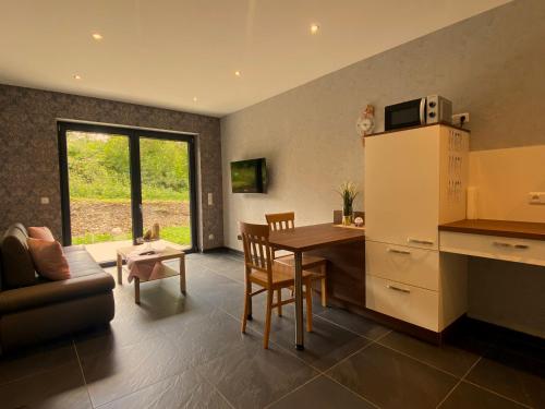 a kitchen and living room with a table and a microwave at Ferienwohnung Am Weiher Kategorie 2 in Nideggen