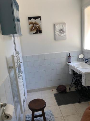 a bathroom with a sink and a stool in it at St Pasha in Paillé