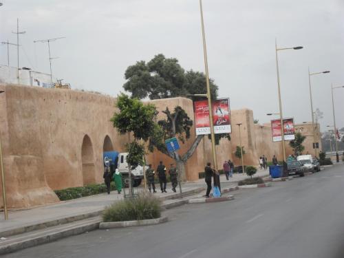 a group of people walking down a street next to a wall at Médina Flat in Rabat