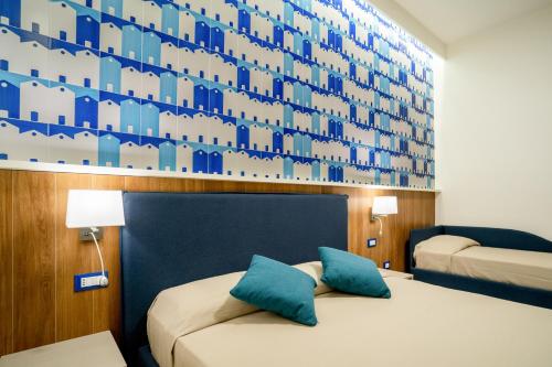 una camera d'albergo con due letti e una parete blu di Cuore di Minori a Minori