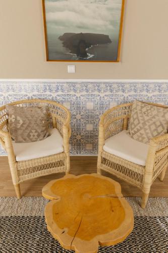two wicker chairs and a table in a room at WOT Ericeira in Ericeira
