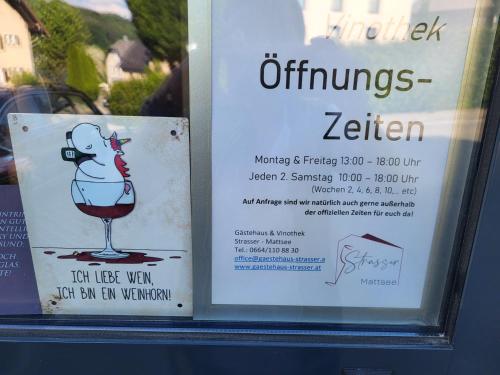 a sign in a window of a wine glass at Gästehaus & Vinothek Strasser in Mattsee