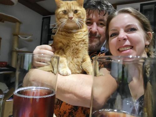 a man and a woman holding a cat on their arms at Gästehaus & Vinothek Strasser in Mattsee