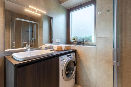 un bagno con lavatrice e lavandino di Il Cortile Suites a Diano dʼAlba