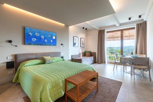 una camera da letto con un letto e un tavolo e una sala da pranzo di Il Cortile Suites a Diano dʼAlba