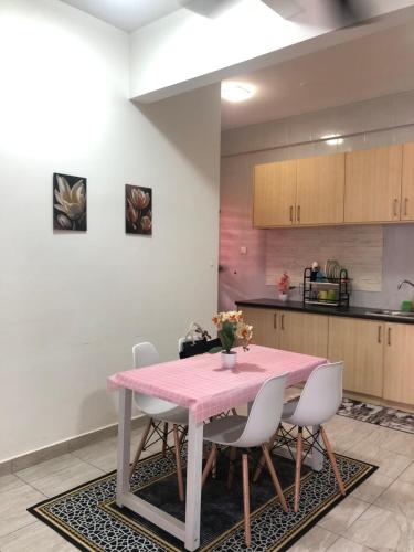 une cuisine avec une table et des chaises roses dans l'établissement HOMESTAY DOABONDA, à Kajang