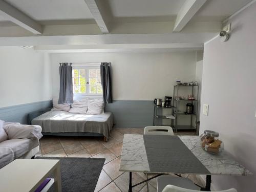 uma sala de estar com uma cama e uma mesa em SOURCE D'HARMONIE L'Écureuil Terres Rouges La Rocaille l'Olivier em Meyreuil