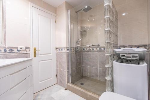 een badkamer met een douche, een toilet en een wastafel bij Apartment in beachfront complex in El Duque area, Costa Adeje in Adeje