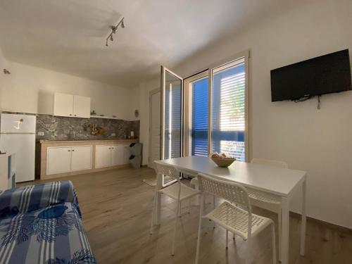 uma cozinha e sala de jantar com uma mesa branca e cadeiras em Gemma Mediterranea em Campomarino