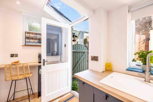 a kitchen with a white door and a sink at The Lymington Sailor's Cottage in Lymington