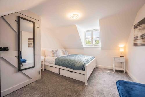 a bedroom with a bed and a mirror at The Lymington Sailor's Cottage in Lymington