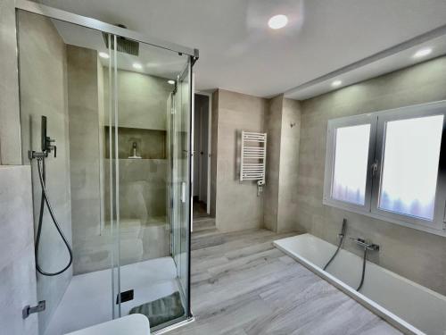 a bathroom with a shower and a tub and a sink at Villa Yolanda del Mar in Arroyo de la Miel