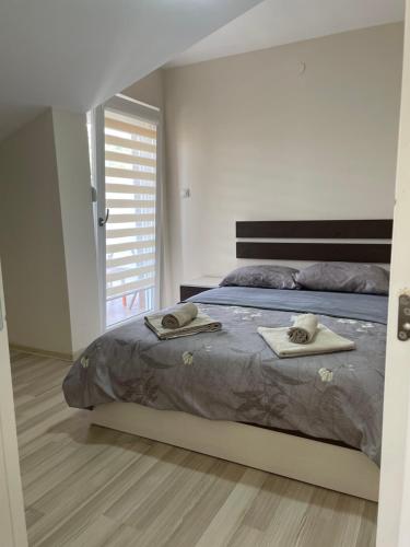 a bedroom with a bed with two towels on it at Apartmani Vrla in Vladičin Han