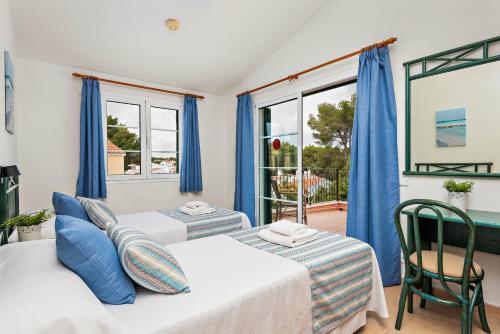 sypialnia z 2 łóżkami i oknem w obiekcie Villas Cala Galdana w Cala Galdana