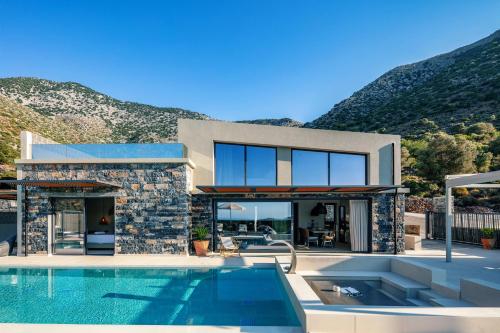 uma casa com piscina ao lado de uma montanha em Troia Villas em Balíon
