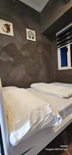 two beds in a room with two windows at SMDC AIR RESIDENCES in Manila