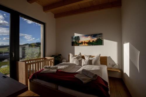 um quarto com uma cama e uma grande janela em An Webers Stoag em Geisingen