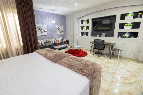 a bedroom with a bed and a table and a desk at Basha Hotel & Restaurant in San Pedro Sula