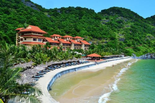 a resort on a beach with chairs and the ocean at PHÚC AN HOSTEL in Cat Ba