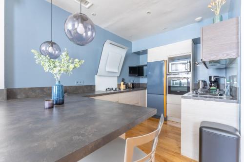 une cuisine avec des murs bleus et une table et des chaises dans l'établissement Vieux-Port - La Caravelle, à Marseille