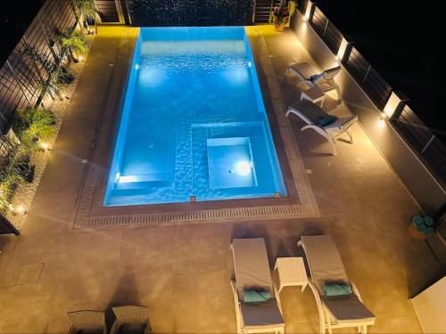 an overhead view of a swimming pool at night with chairs at Flev's Luxury House with pool in Kremasti