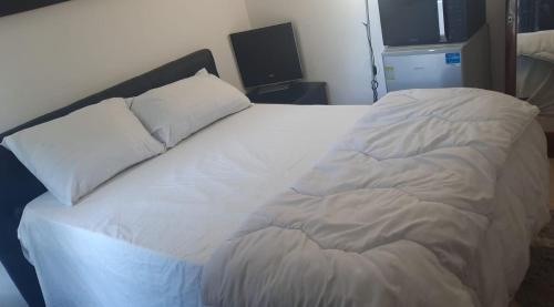 - un lit blanc avec 2 oreillers dans l'établissement JUST ROOMS, à Sarcelles