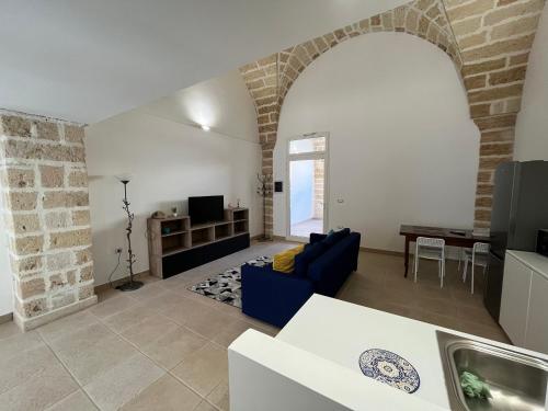 a living room with a blue couch and a table at Casa Vittoria in Squinzano