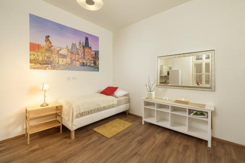 a white bedroom with a bed and a mirror at Unesco Prague Apartments in Prague
